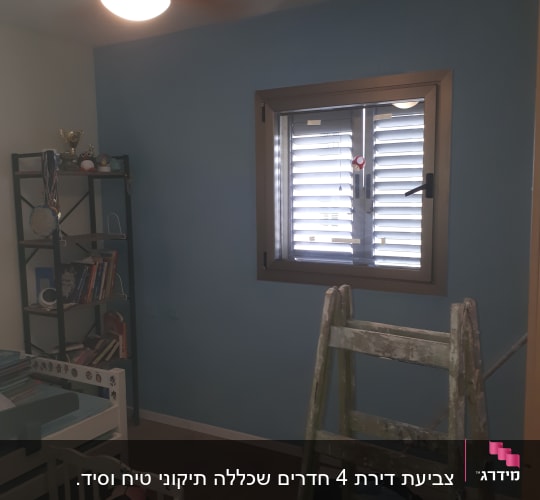 סולם עץ ישן בחדר צבוע בצבע כחול